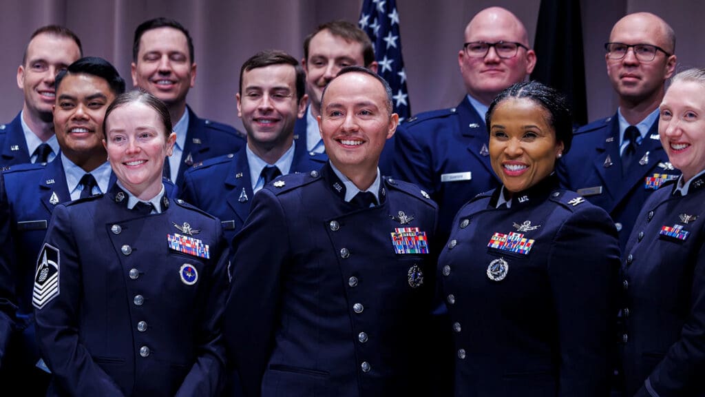 Smiling members of the U.S. Space Force in military dress